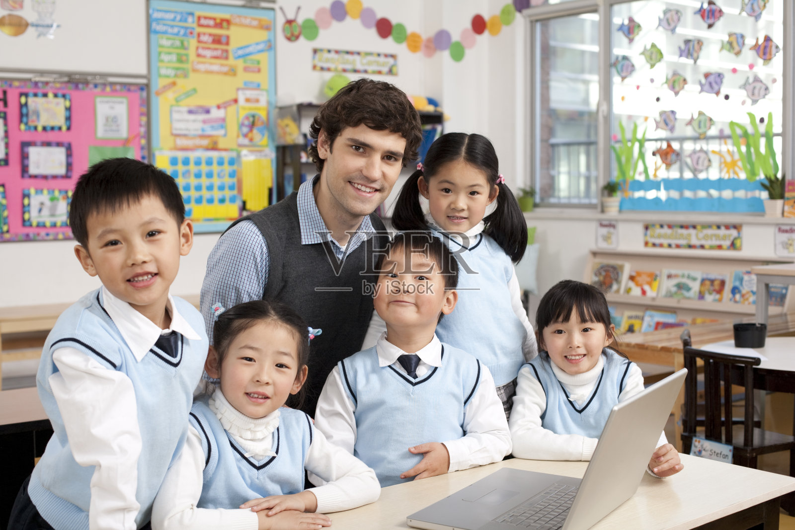 老师在课堂上辅导小学生用电脑照片摄影图片