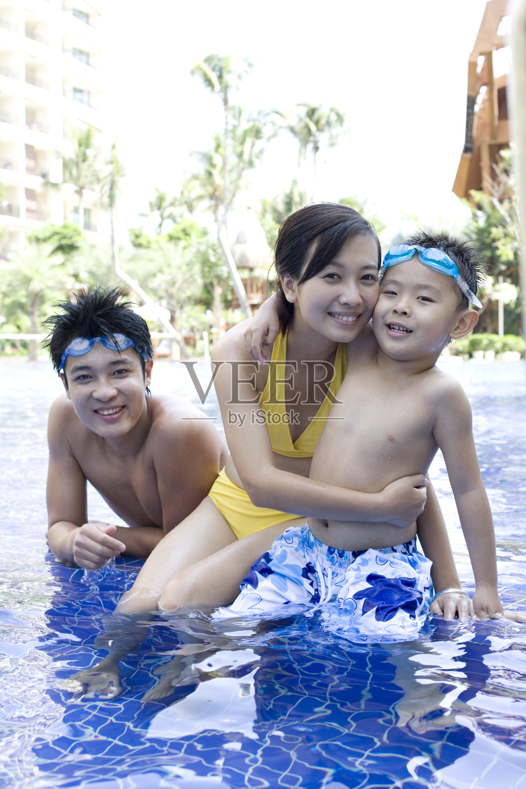 一家三口在游泳池边玩耍照片摄影图片