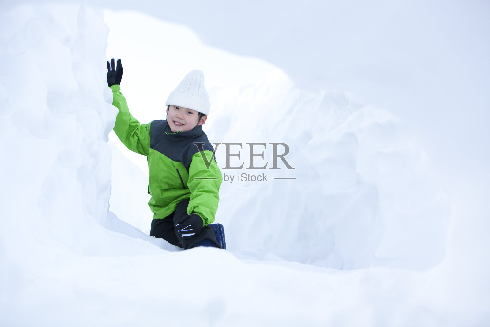 小男孩在雪地嬉戏照片摄影图片