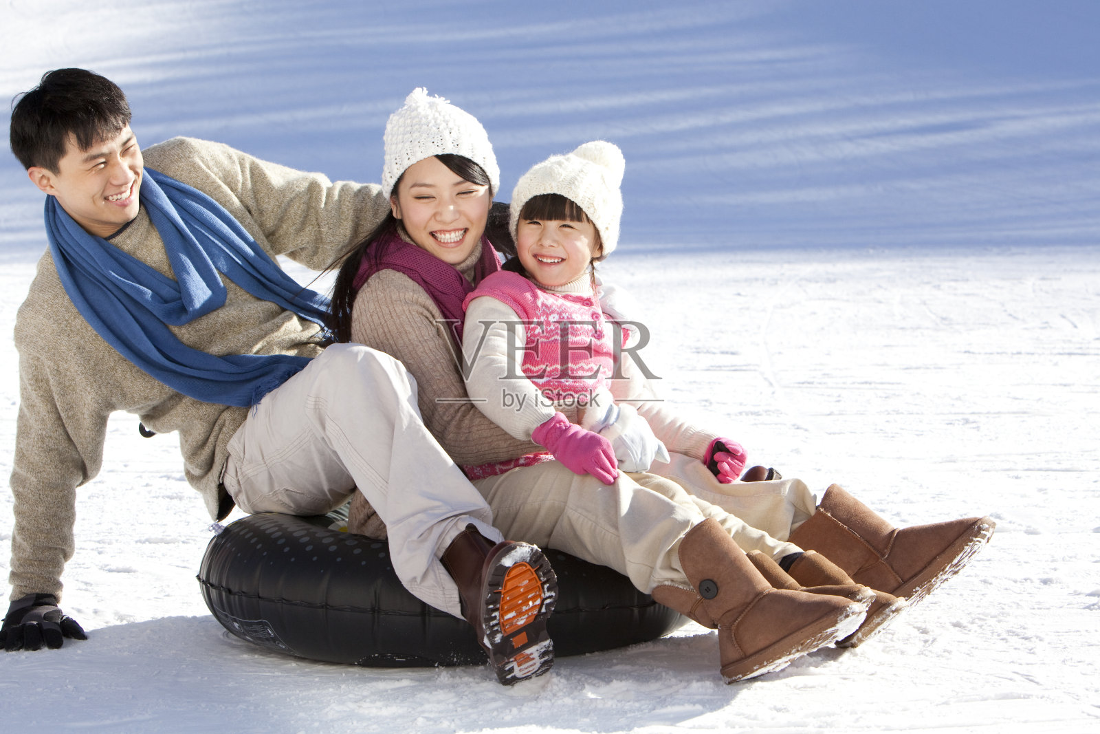 一家三口在雪地嬉戏照片摄影图片
