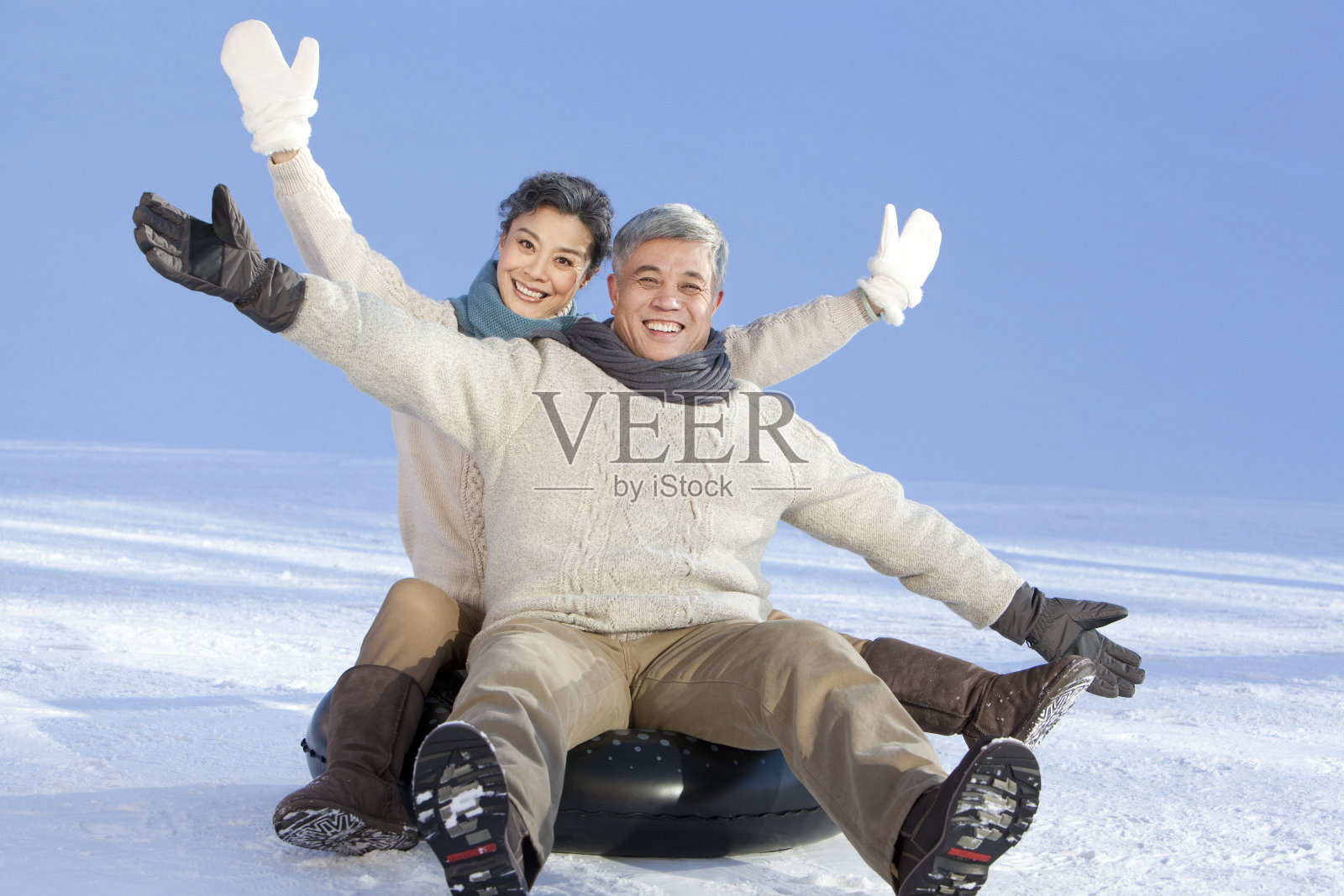 老年夫妇在雪地嬉戏照片摄影图片