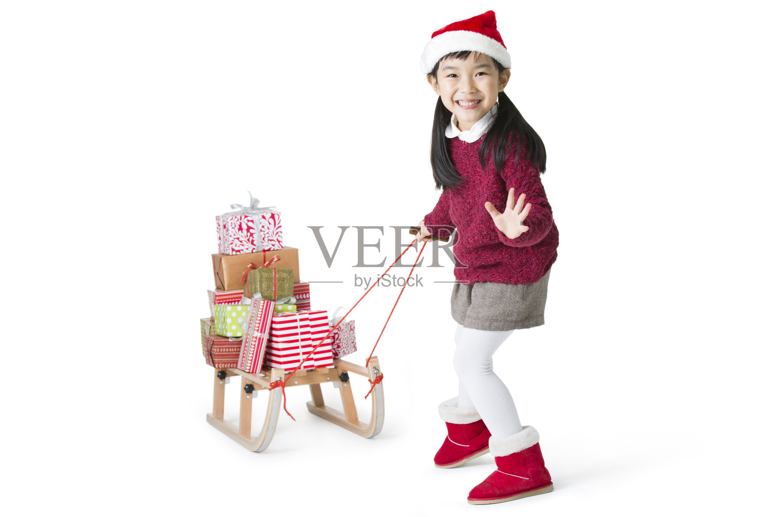 小女孩拉着雪橇运送圣诞礼物照片摄影图片