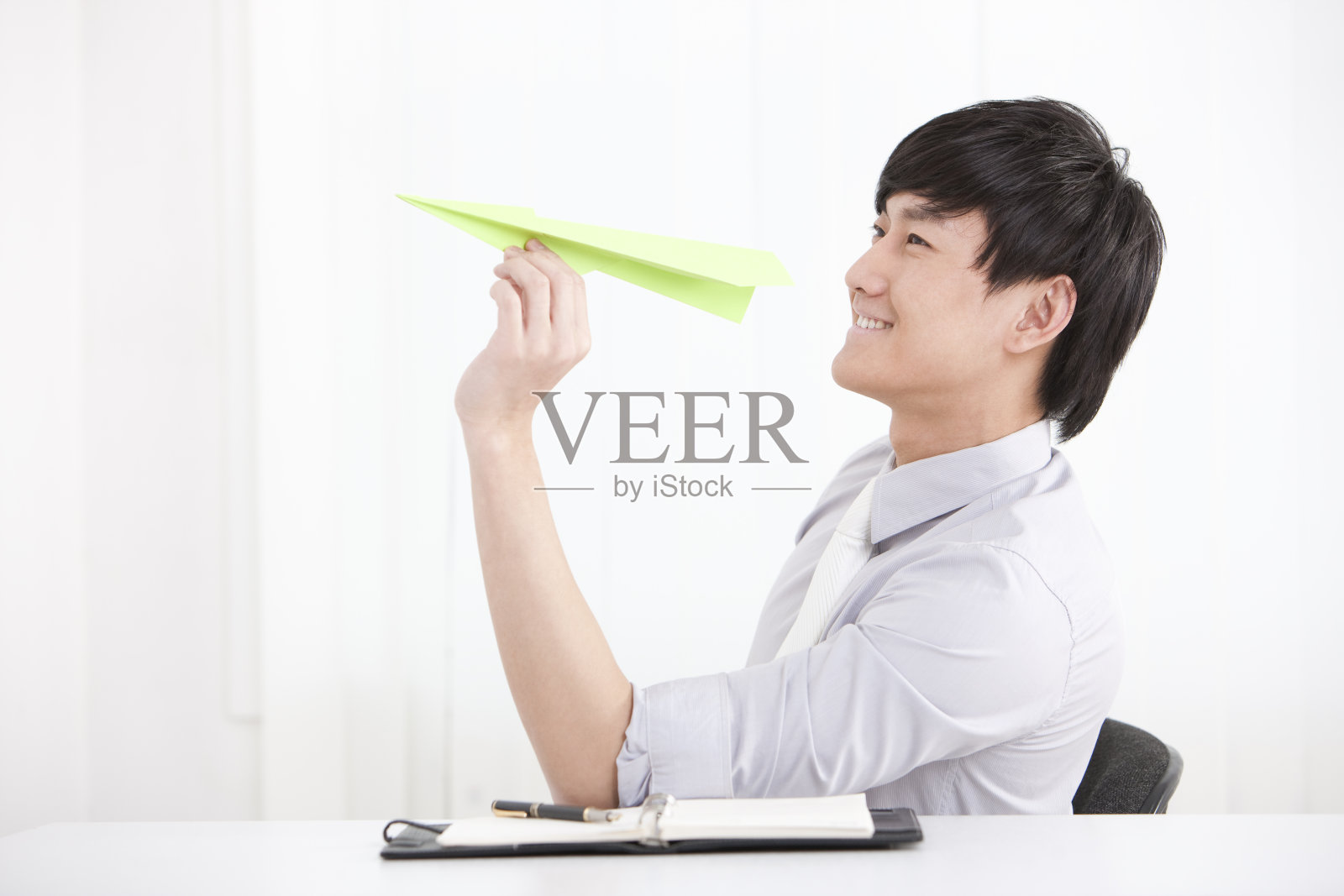 拿着纸飞机的商务男士照片摄影图片