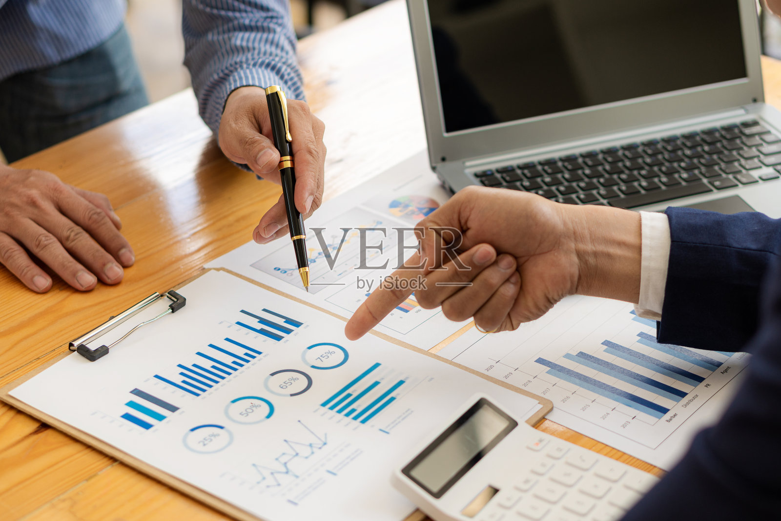 业务团队拿笔指着文件讨论财务数据和报告图表业务咨询工作会议和头脑风暴新的业务项目财务投资的想法照片摄影图片