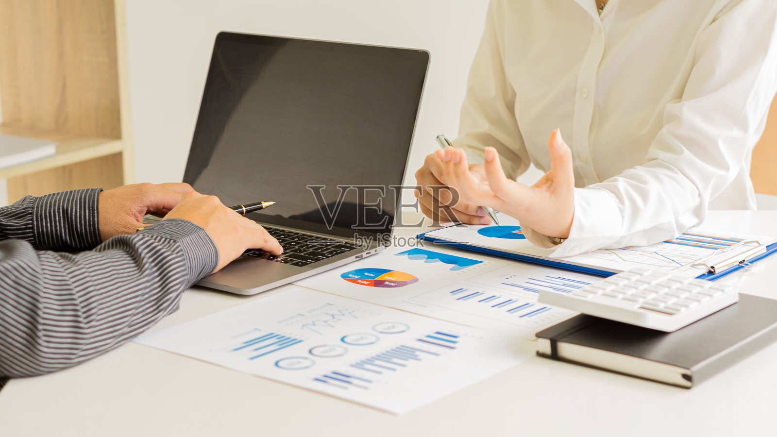 业务团队拿笔指着文件讨论财务数据和报告图表业务咨询工作会议和头脑风暴新的业务项目财务投资的想法照片摄影图片