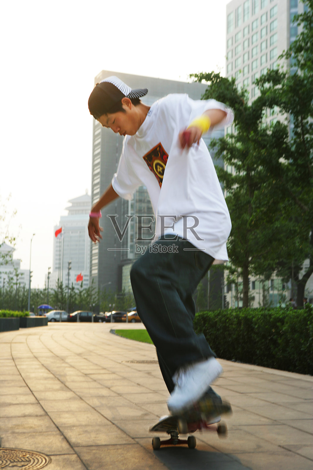 男青年在写字楼下玩滑板照片摄影图片