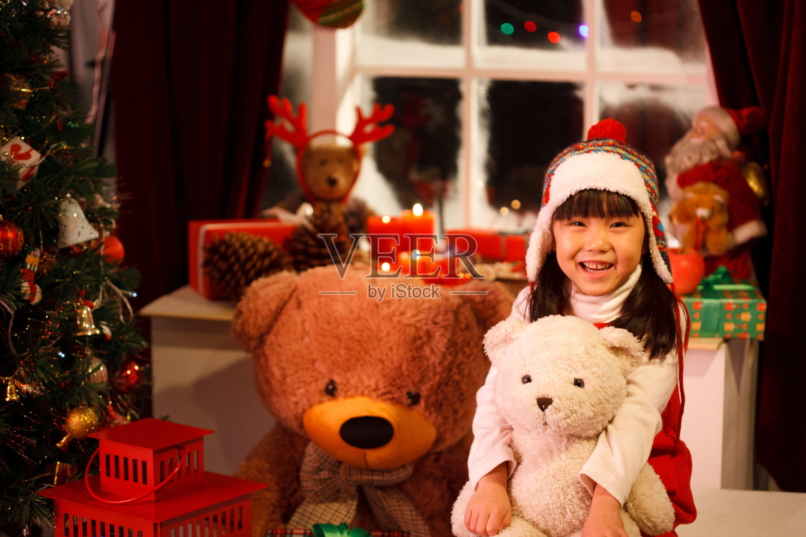 小女孩圣诞节抱着玩具熊照片摄影图片