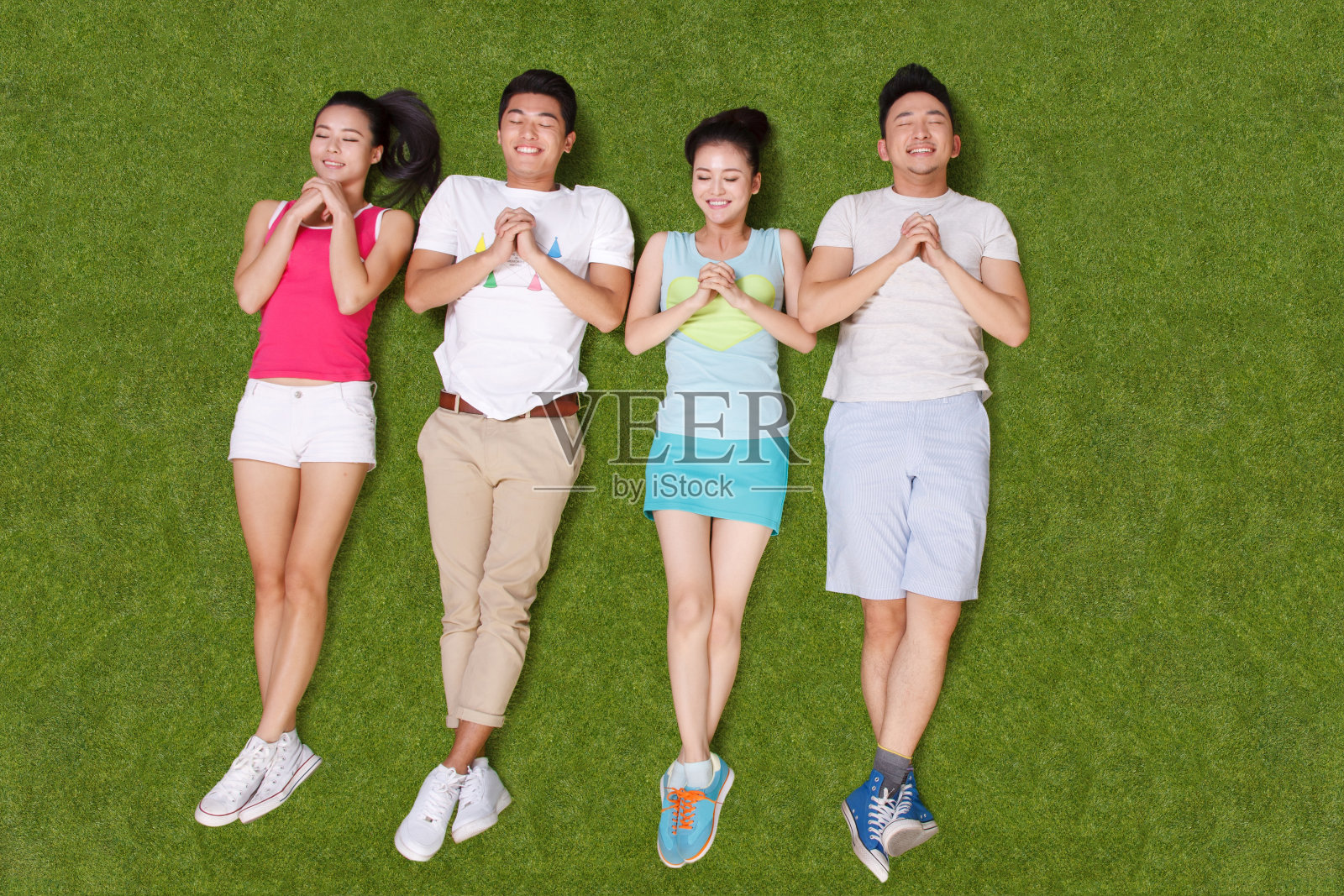 青年男女躺在草地上嬉戏照片摄影图片