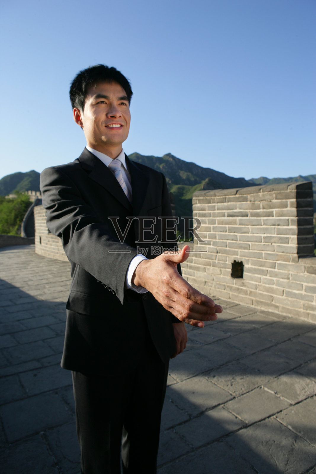 商务人士在长城上伸出手照片摄影图片