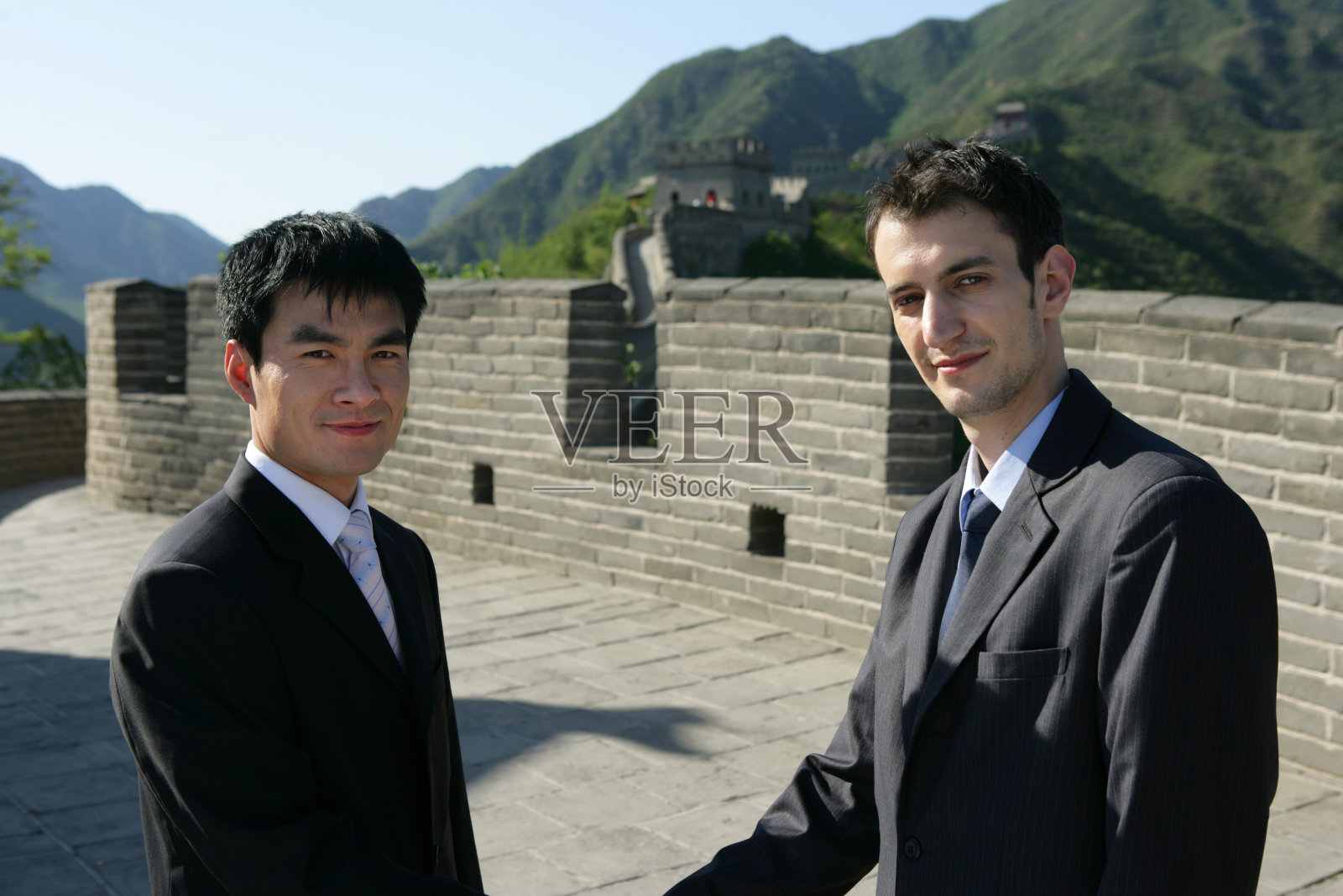 两位中外商务人士在长城上握手照片摄影图片