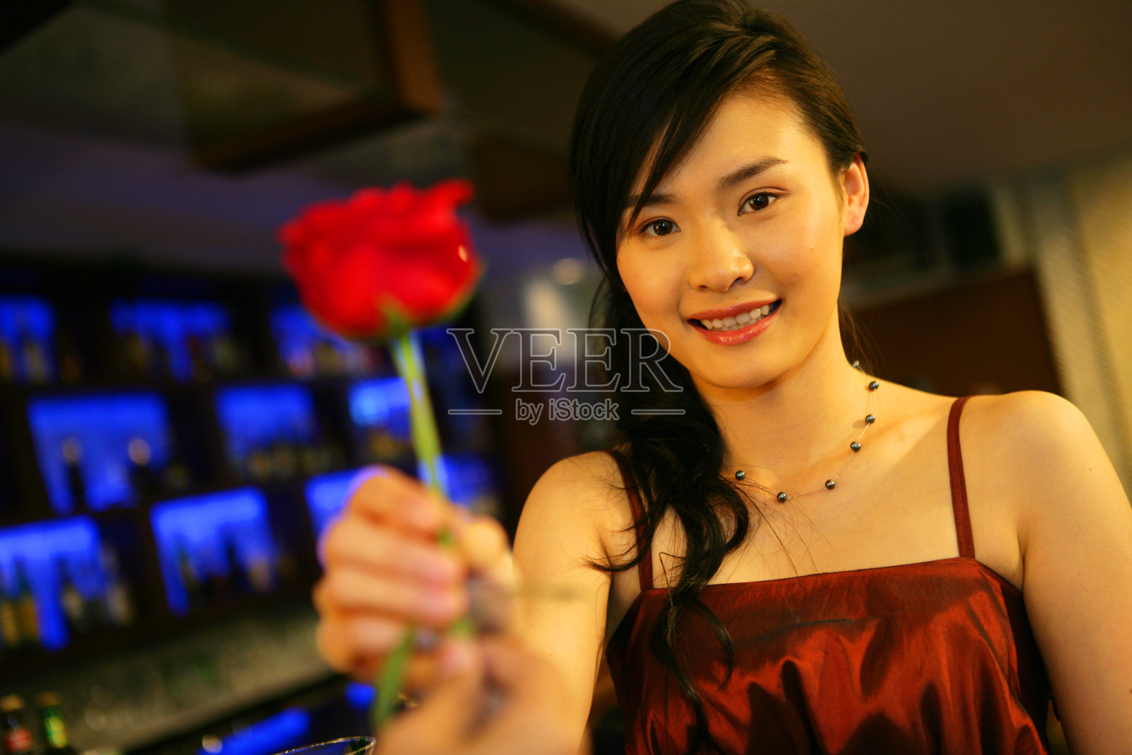 年轻女士在酒店酒吧收到玫瑰花照片摄影图片