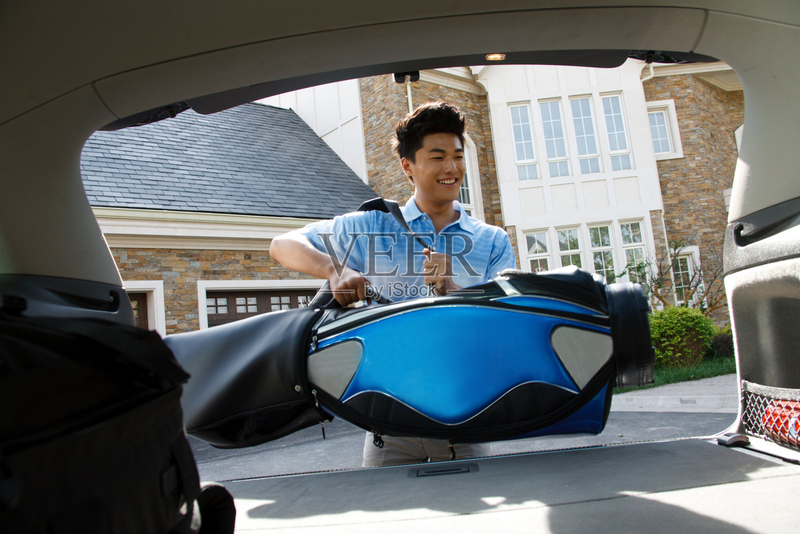 一个青年男人背着高尔夫球包照片摄影图片