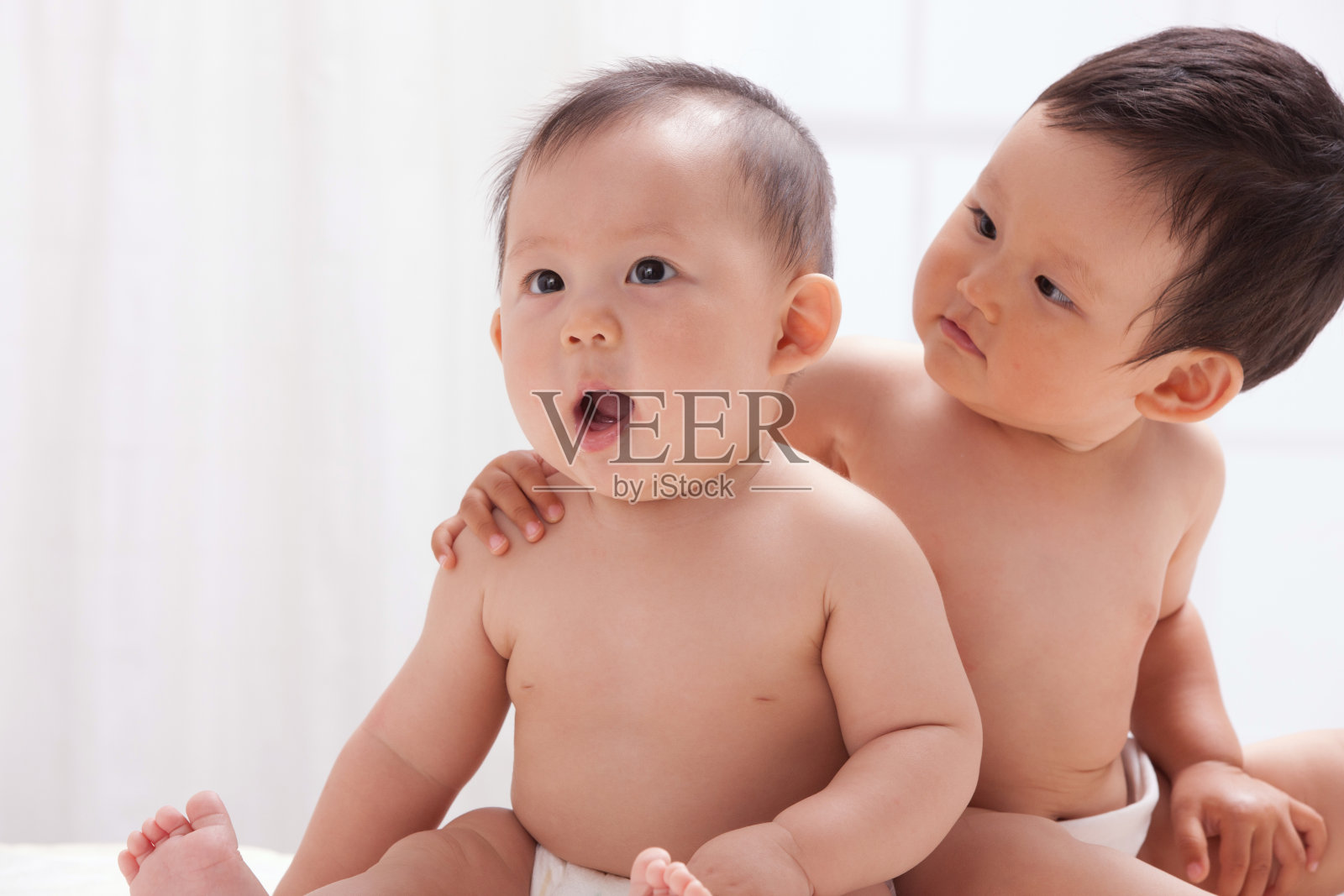 两个婴儿坐在室内床上照片摄影图片