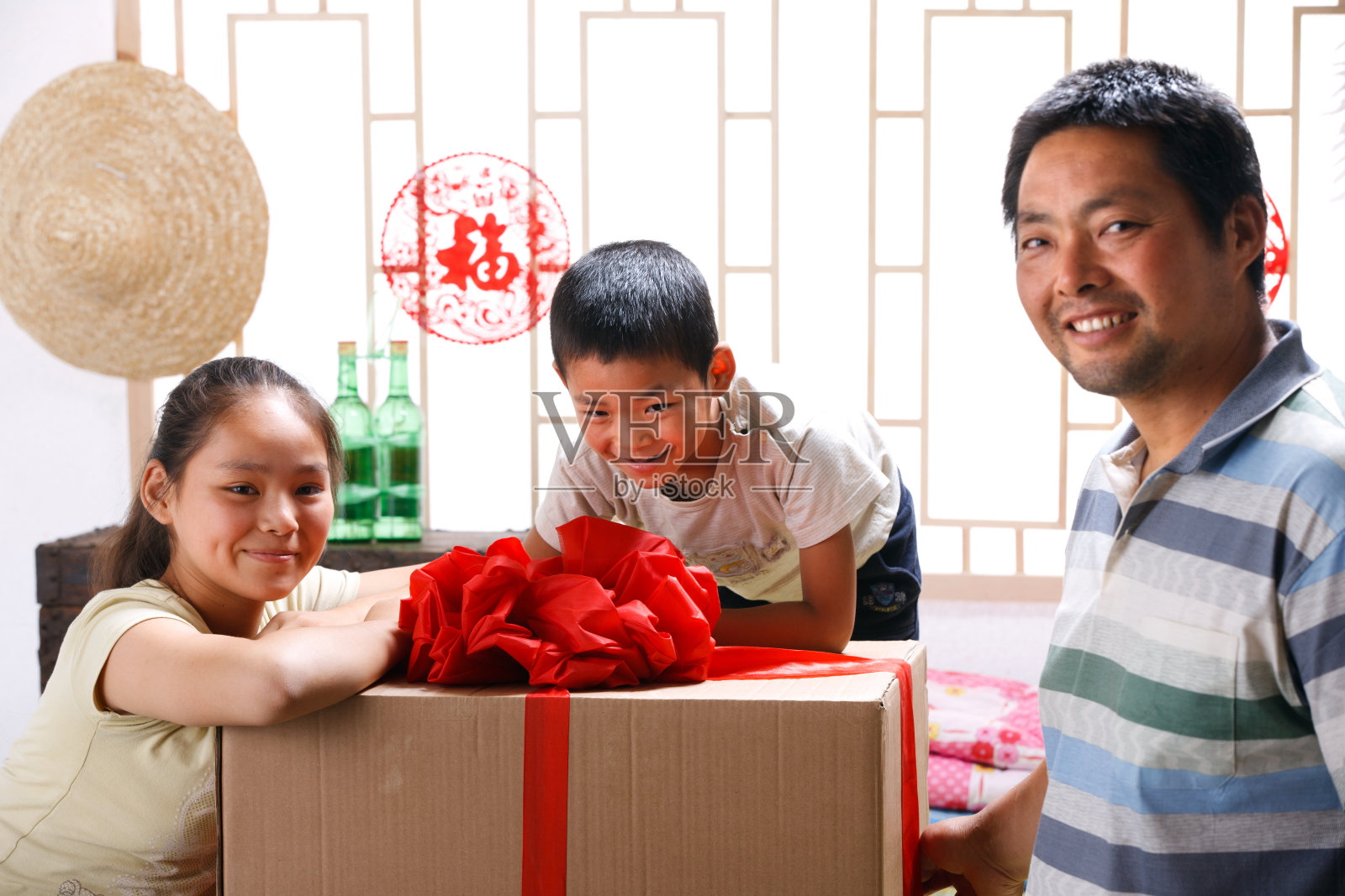 农民父子扶着电器包装箱照片摄影图片