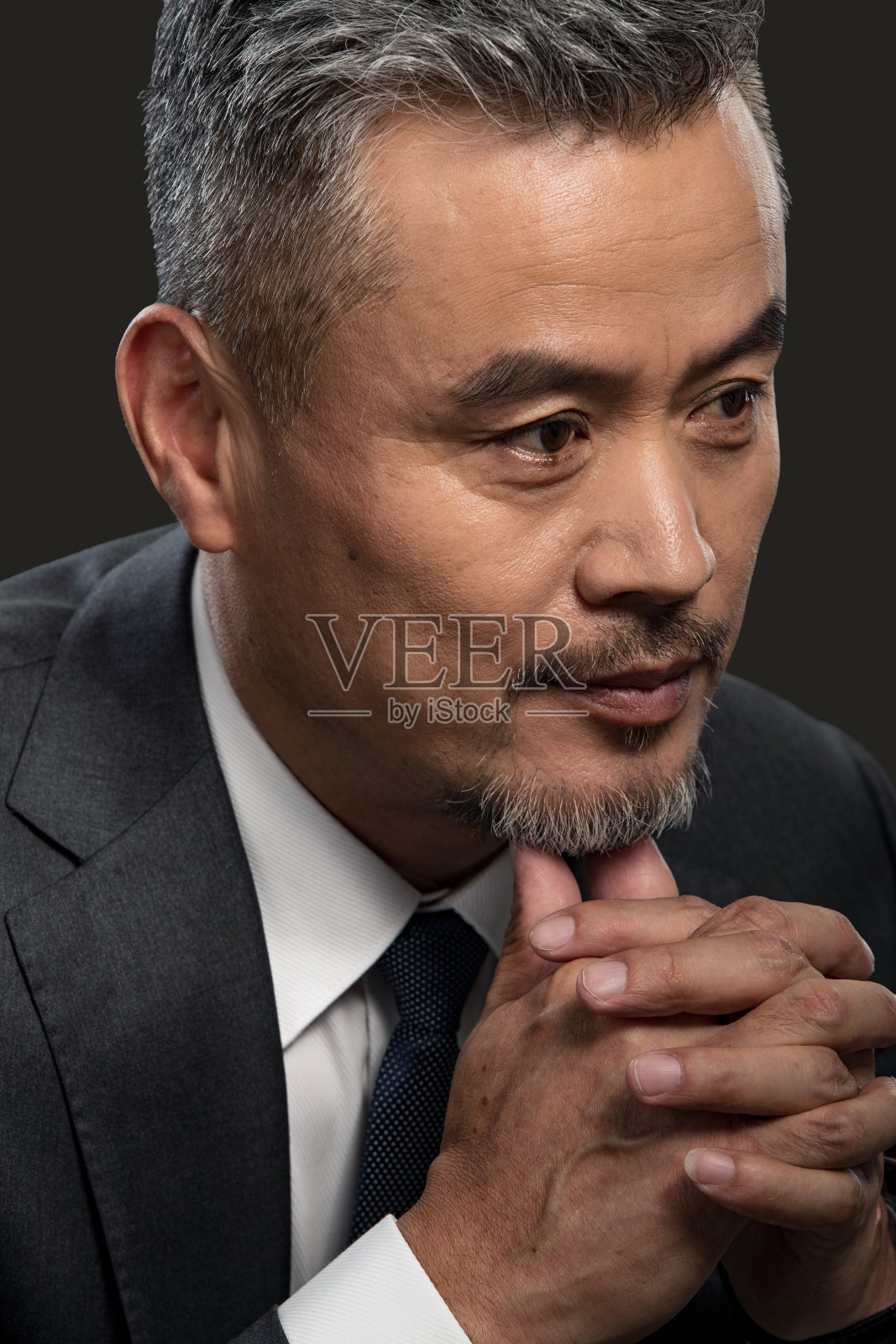 用手指触摸下巴思考的商务男士特写照片摄影图片