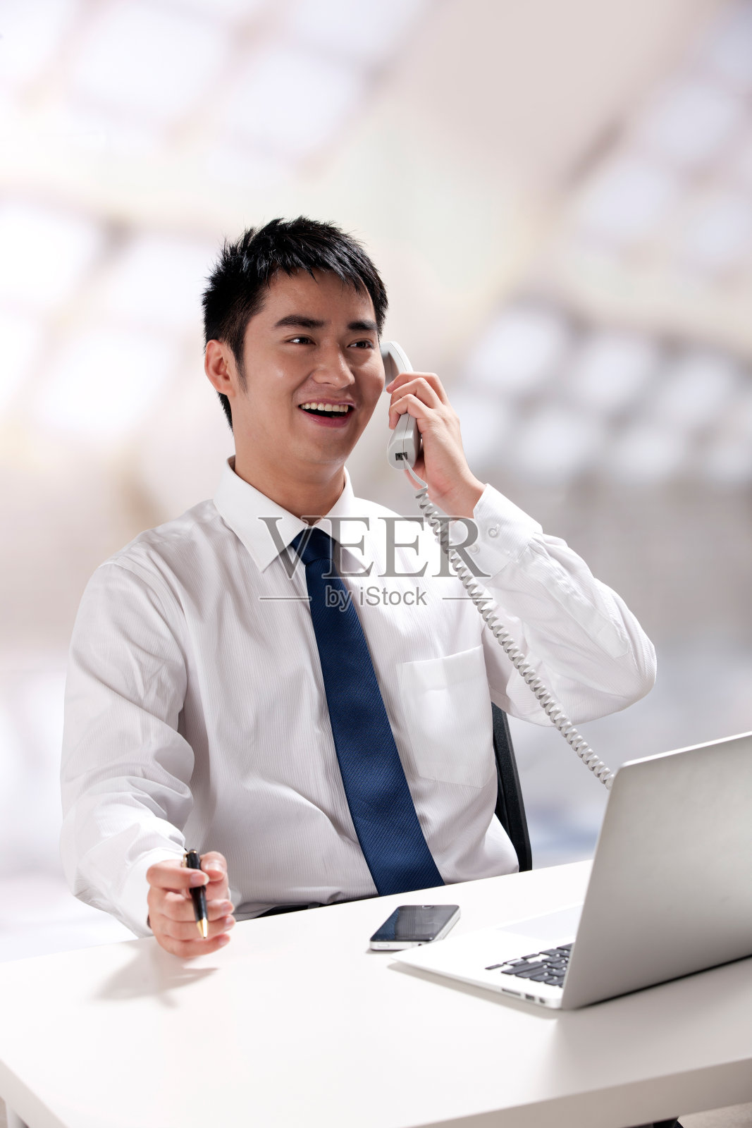 青年商务男士在办公室里打电话照片摄影图片