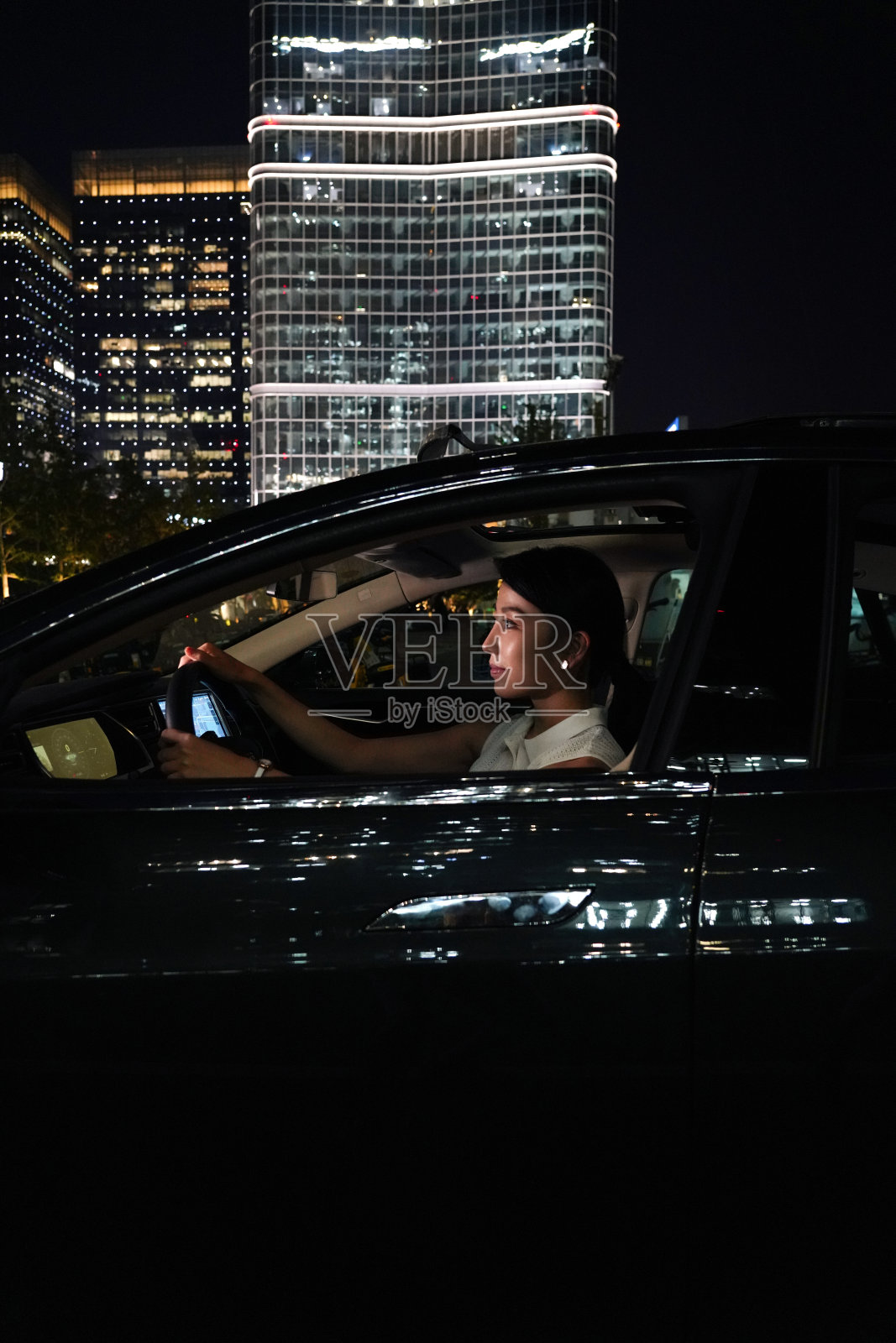 夜晚漂亮的年轻女人驾车照片摄影图片