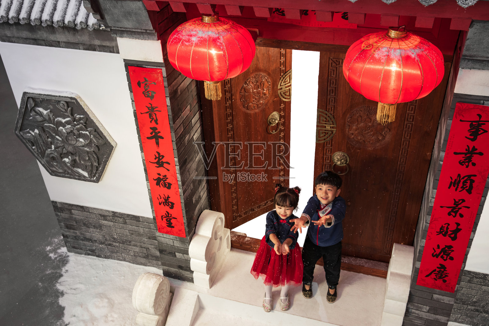 站在庭院门口玩耍的男孩女孩照片摄影图片