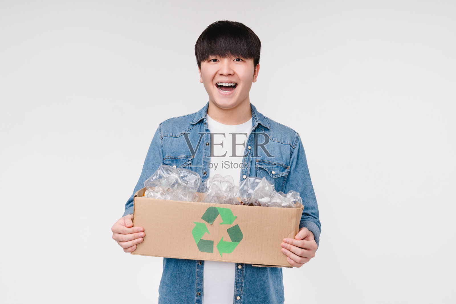 快乐的环保亚洲韩国活动家举着一个装满塑料瓶回收。环保，地球日理念照片摄影图片