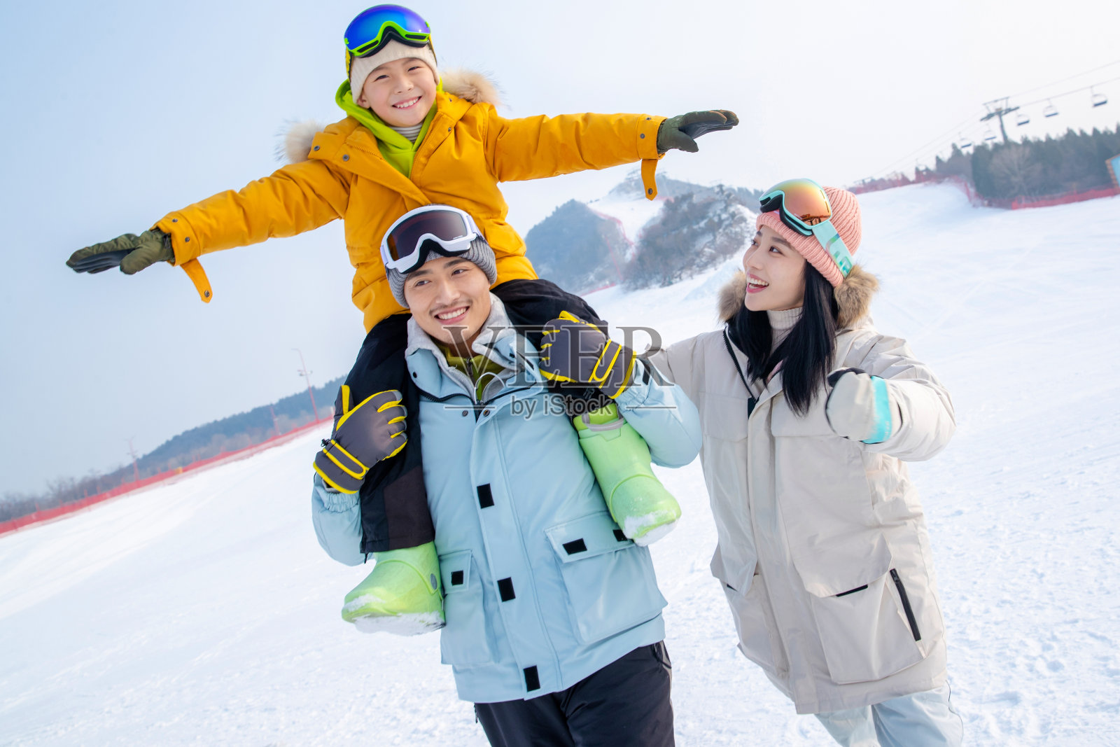 来滑雪场度假的快乐三口之家照片摄影图片