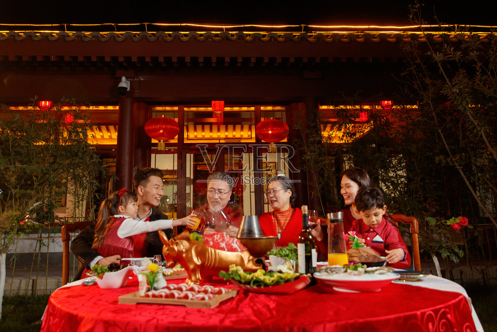 春节东方家庭在中式庭院内聚餐照片摄影图片