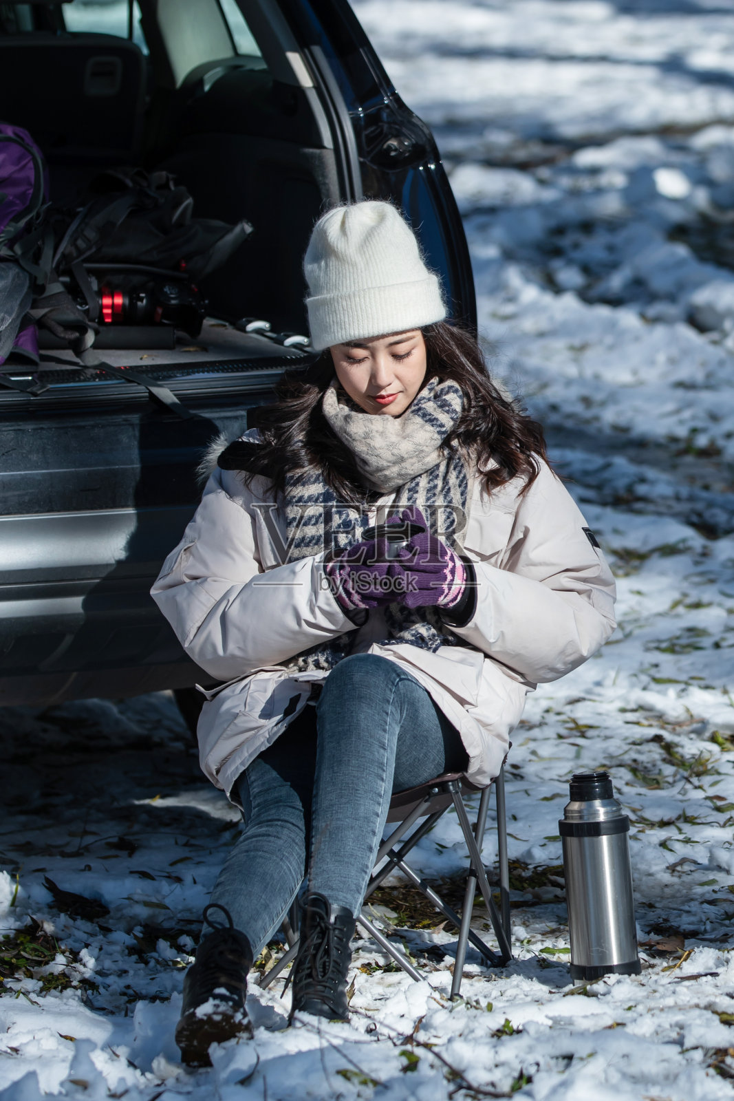 坐在汽车旁喝热水的青年女人照片摄影图片