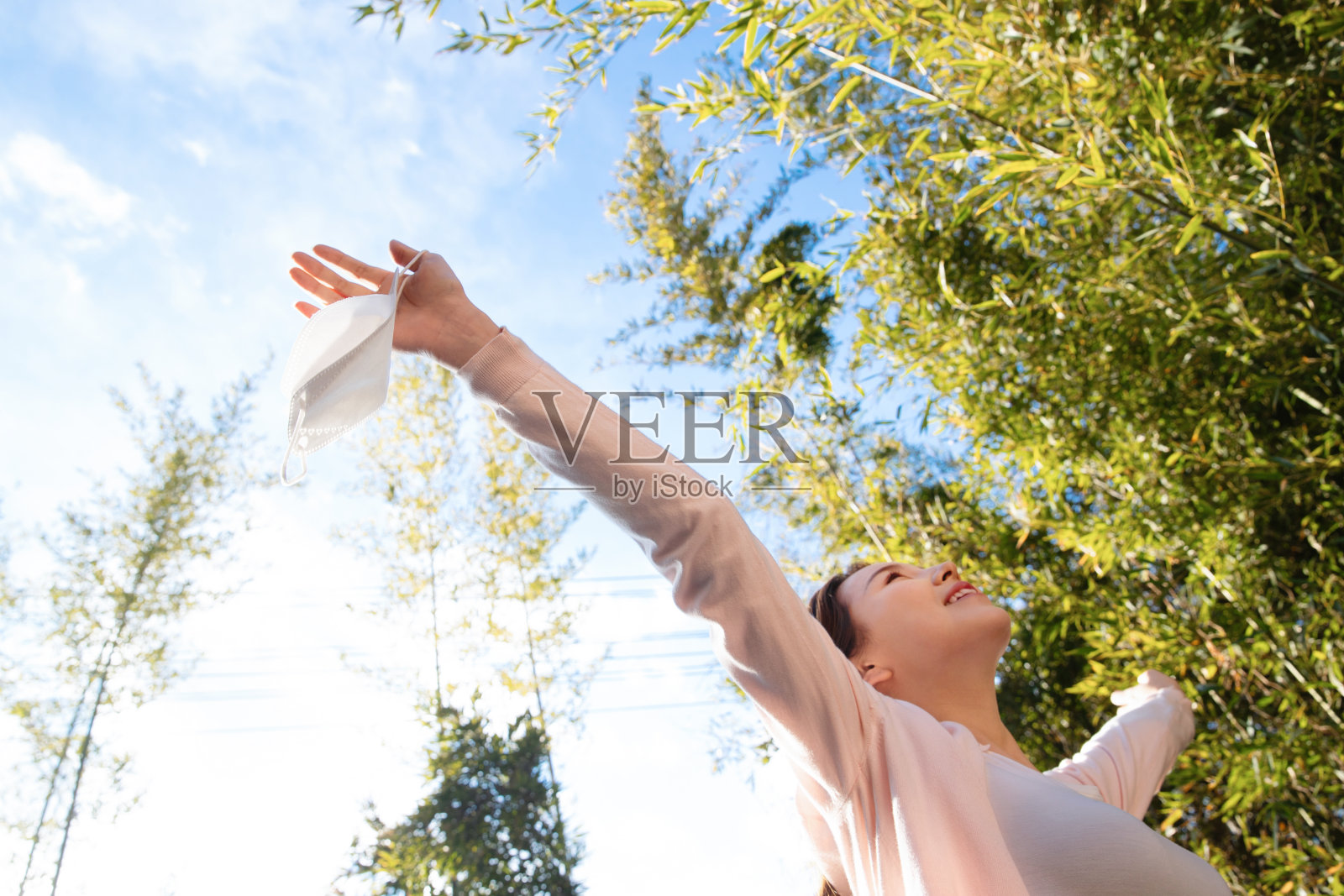 在户外拿着口罩的青年女人照片摄影图片