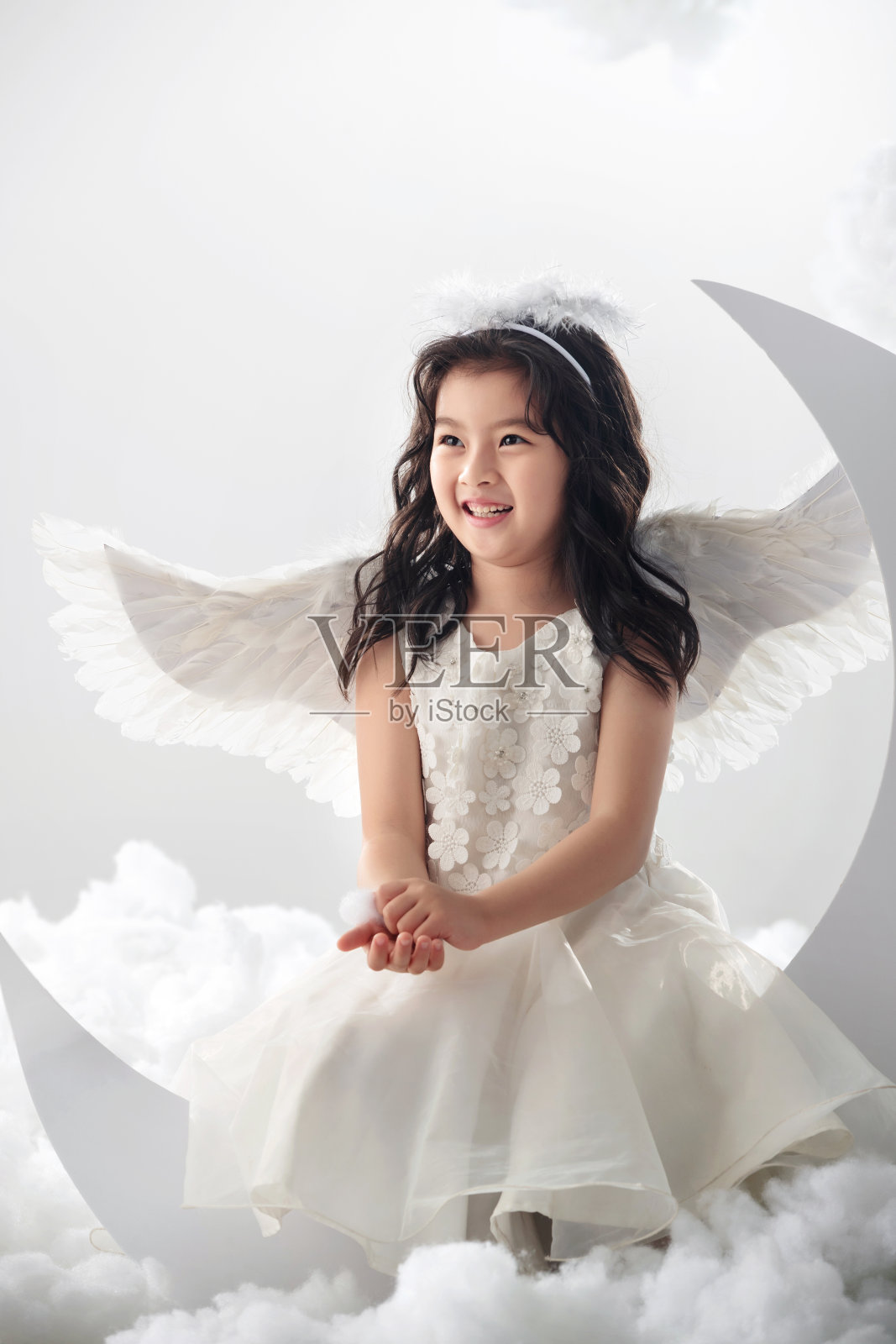 坐在月亮上的快乐小天使照片摄影图片