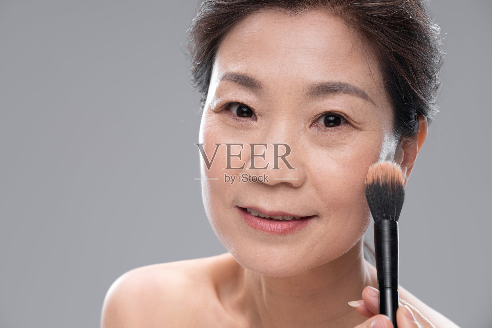拿着化妆刷的中年女人照片摄影图片