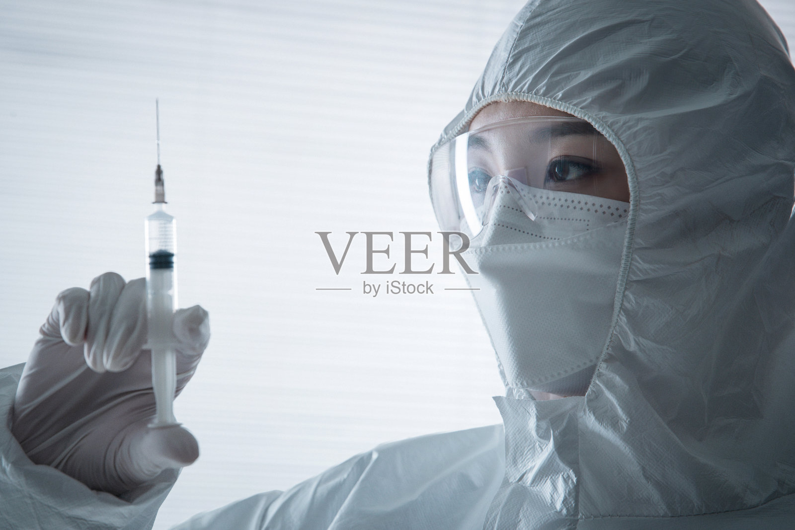穿防护服的医生拿着注射器照片摄影图片