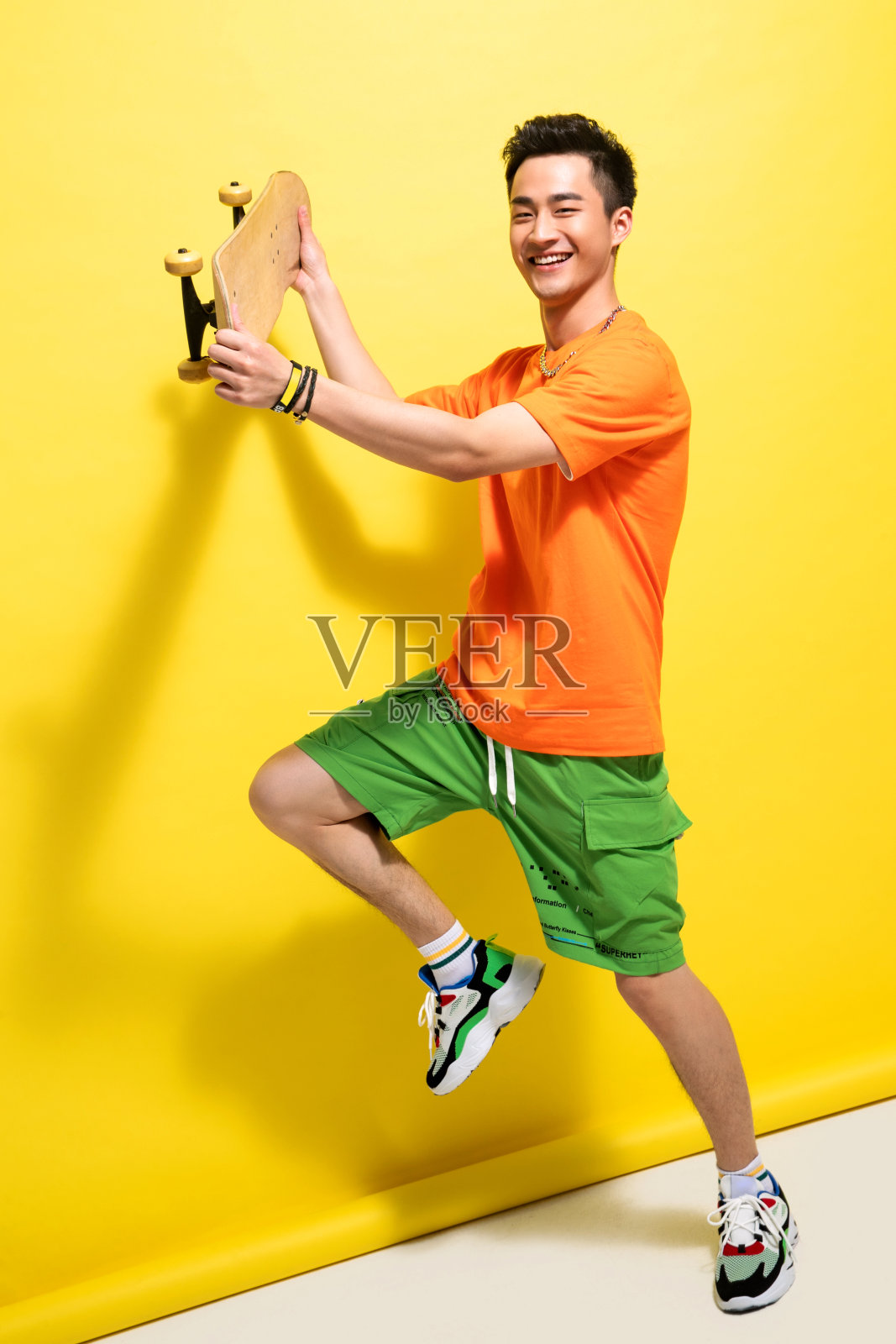 兴奋的青年男人举着滑板照片摄影图片