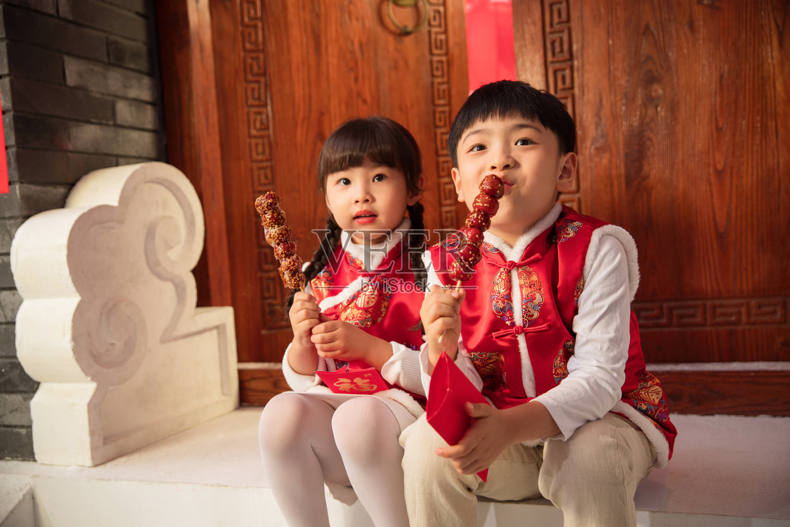 吃冰糖葫芦的可爱男孩女孩照片摄影图片