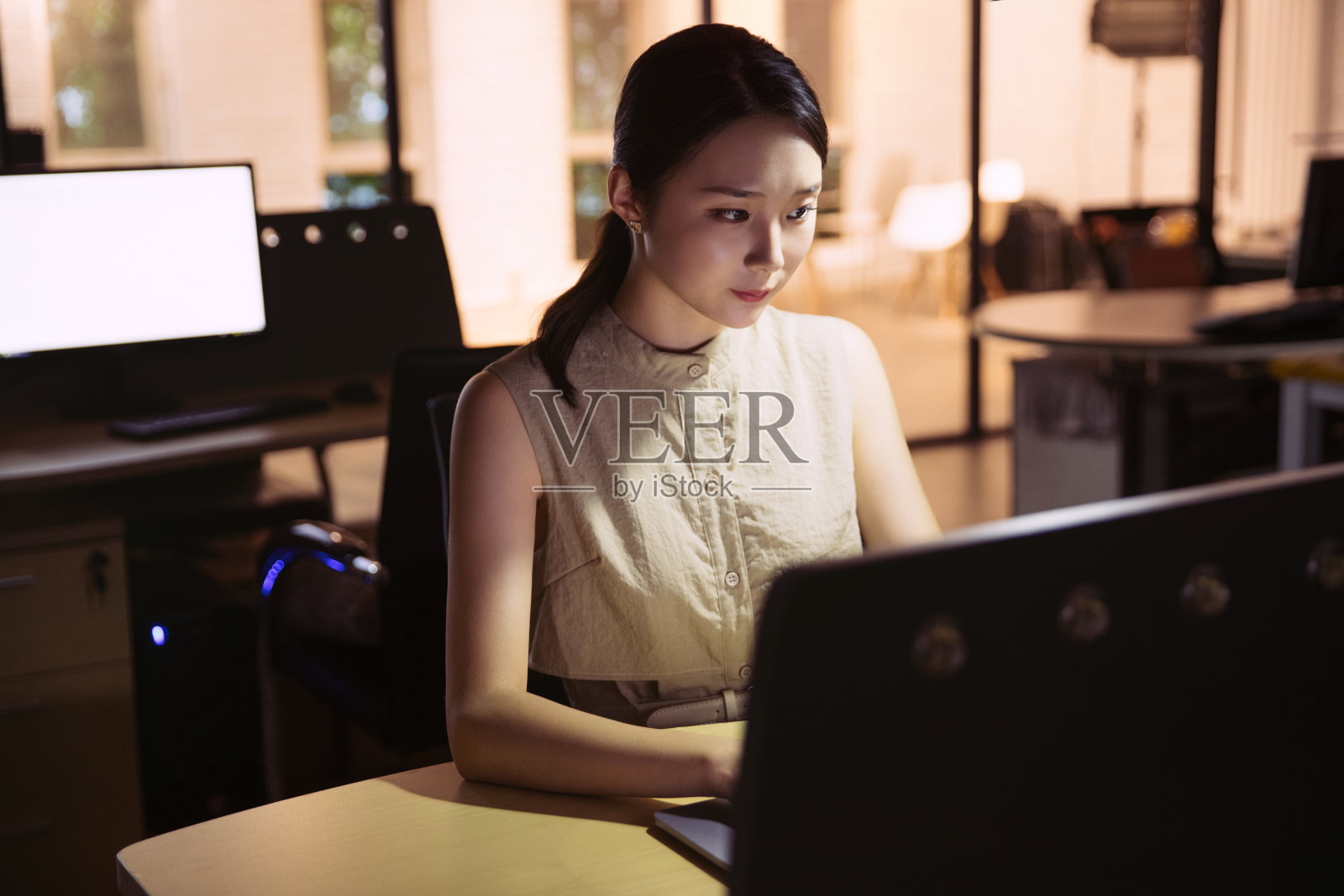 在办公室加班的年轻女士照片摄影图片