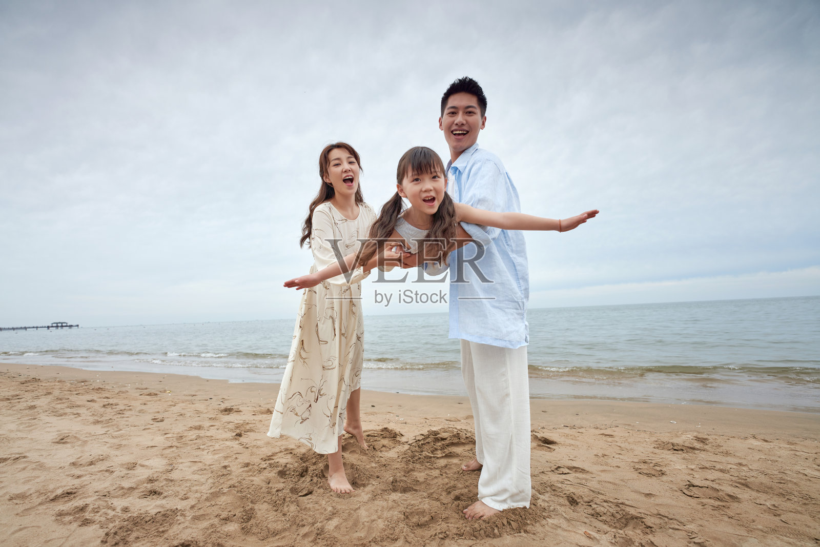 一家三口在海边玩耍照片摄影图片