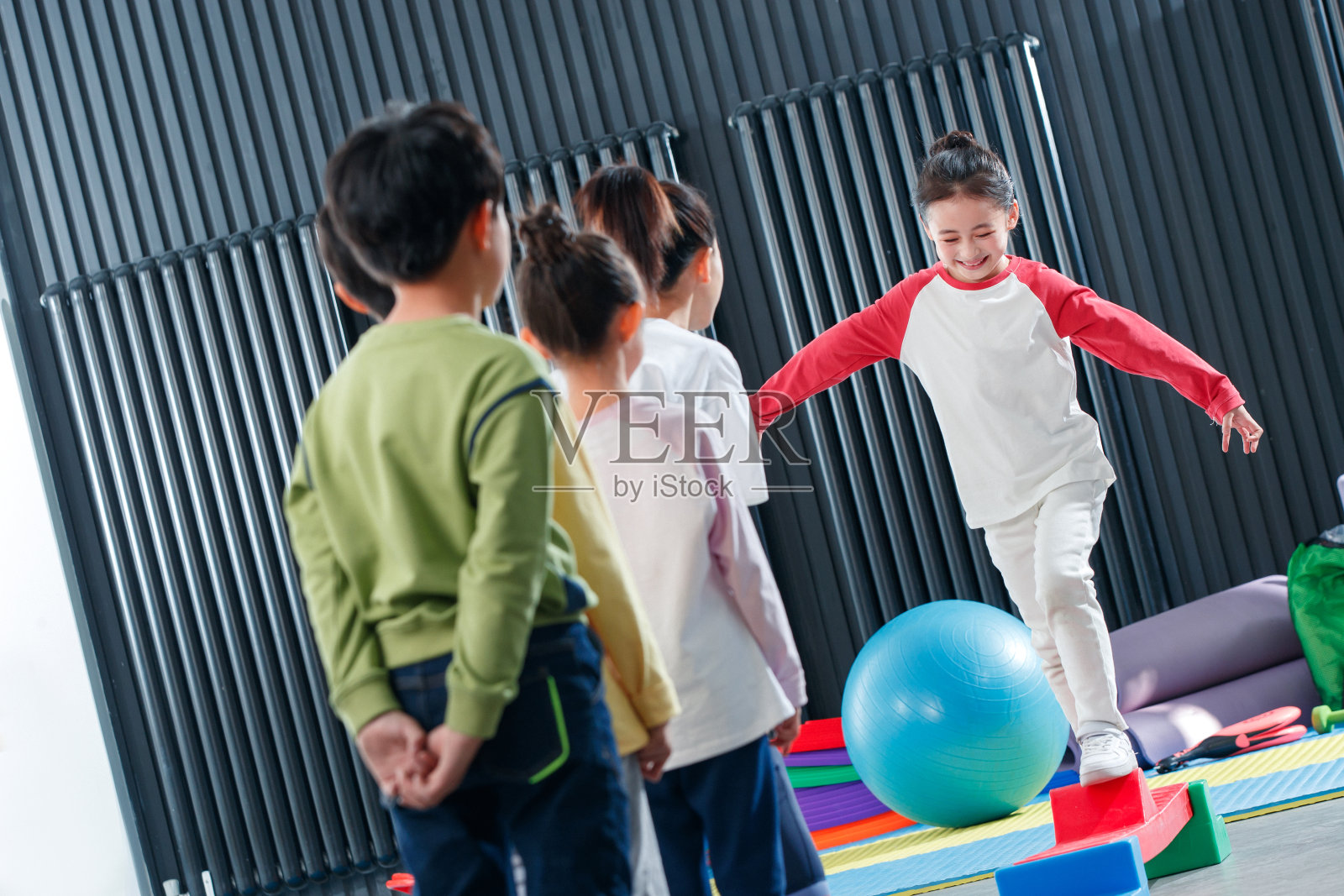 儿童在教练的指导下进行平衡木训练照片摄影图片