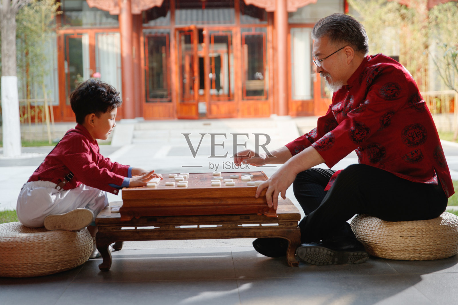 祖孙俩在庭院里下象棋照片摄影图片