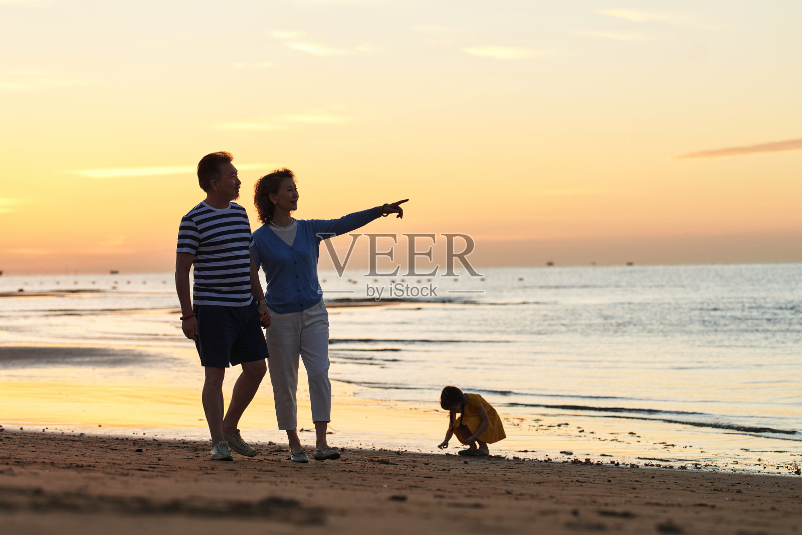 老年夫妇在海边散步照片摄影图片