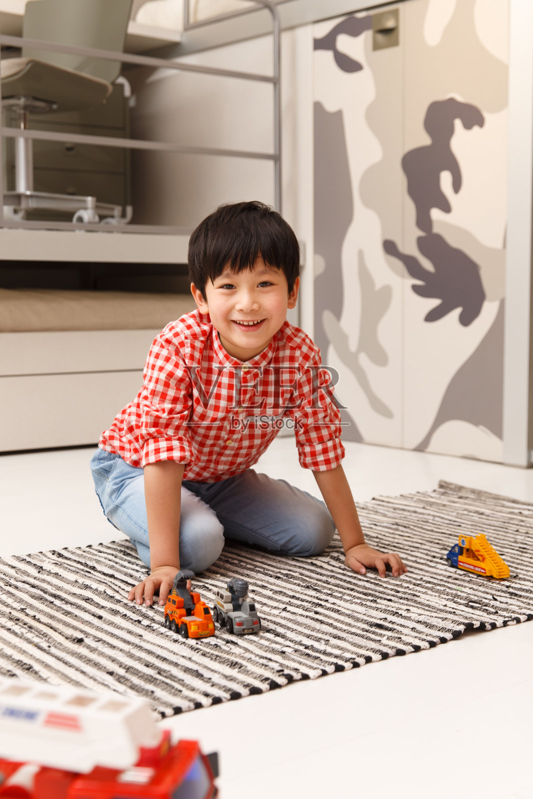小男孩在地毯上玩耍照片摄影图片