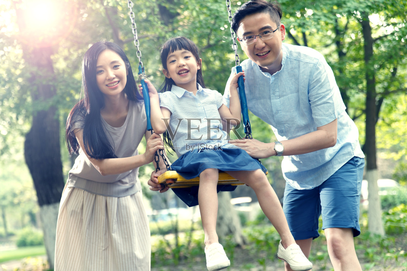 快乐的一家三口荡秋千照片摄影图片