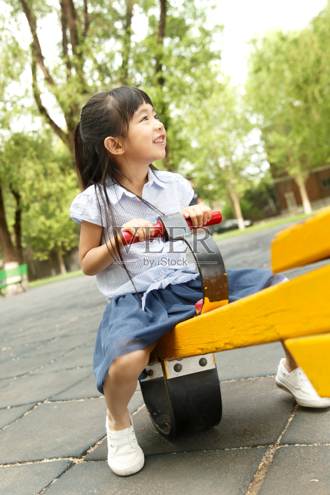 小女孩坐跷跷板照片摄影图片