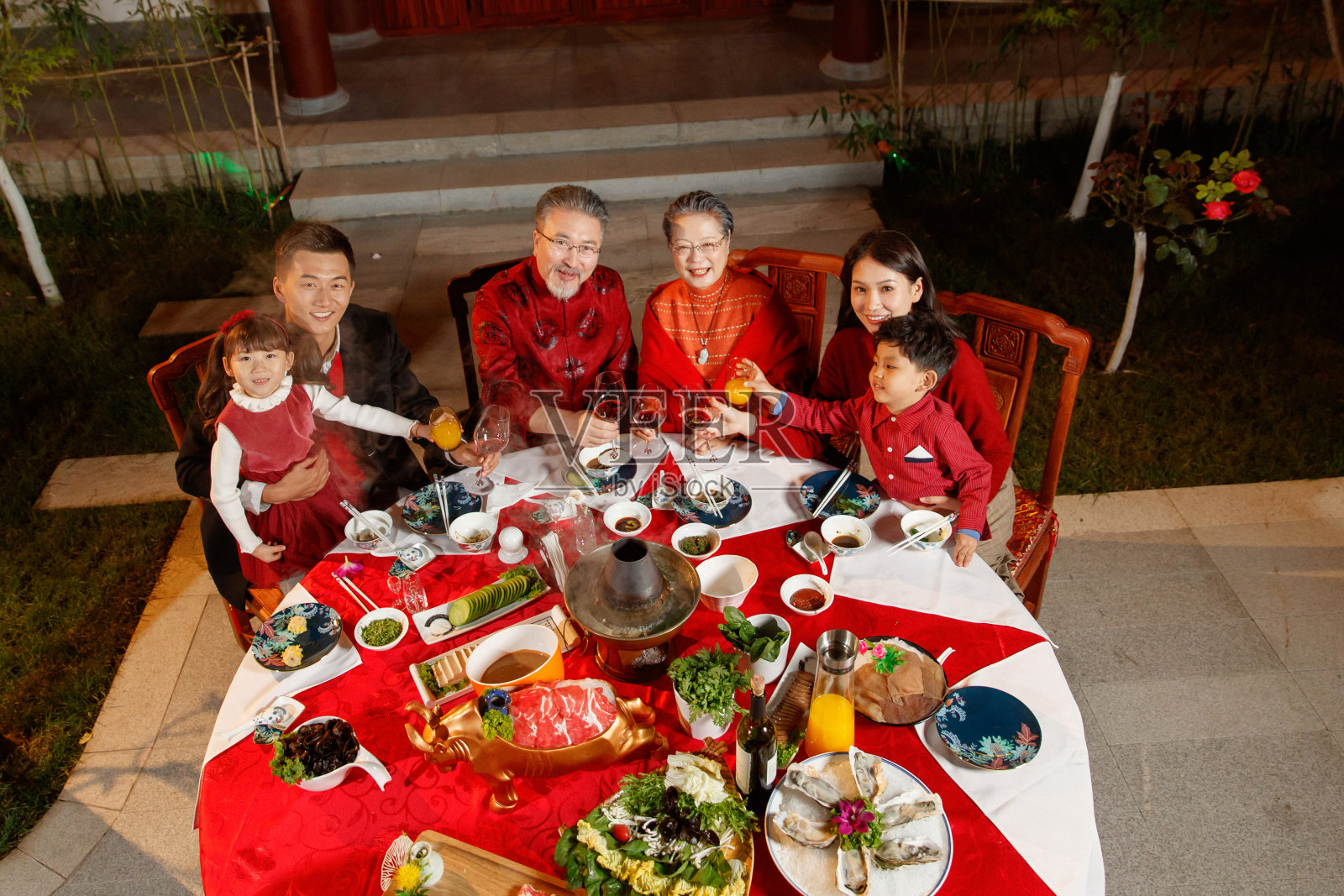 东方家庭在中式庭院内干杯庆祝新年照片摄影图片