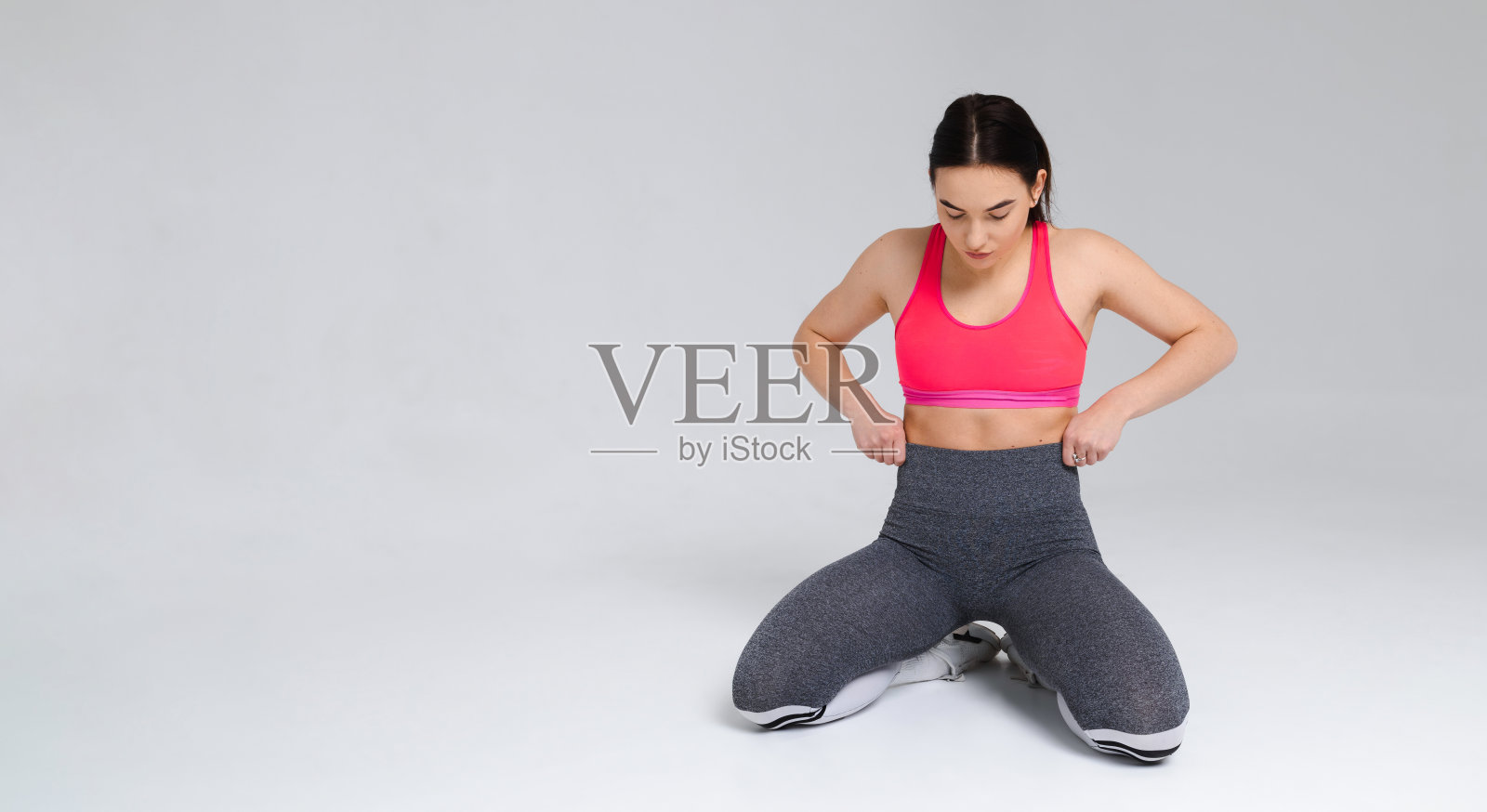 美丽的女孩在运动服装摆姿势在白色的工作室背景照片摄影图片