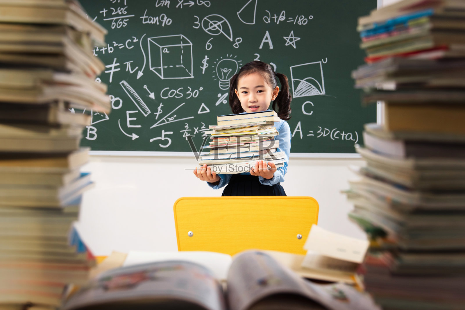 搬着沉重课本的小学女生照片摄影图片