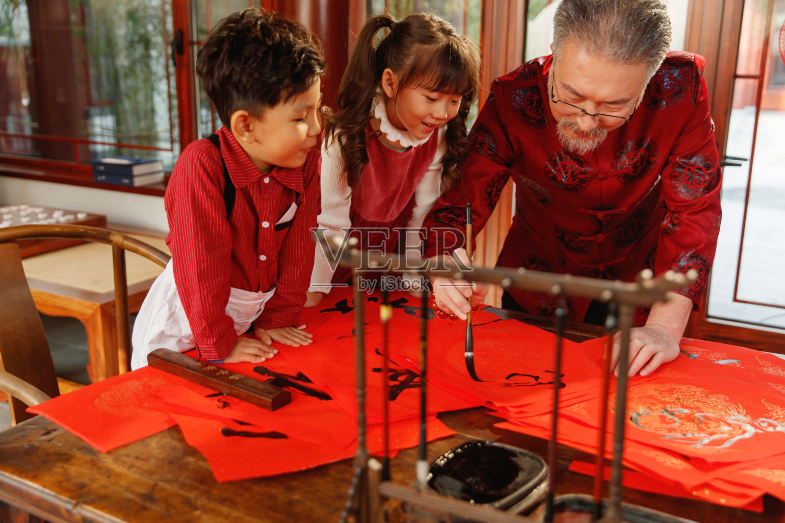祖孙三人一起写春联照片摄影图片
