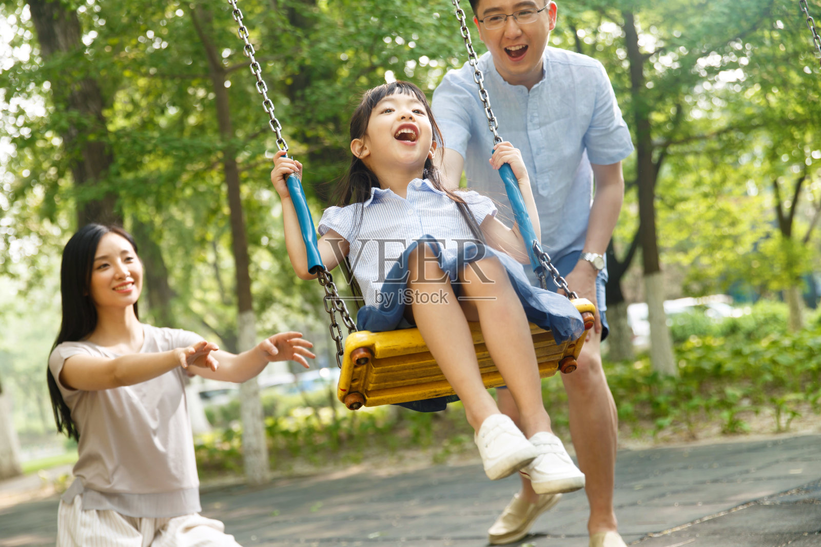 快乐的一家三口荡秋千照片摄影图片