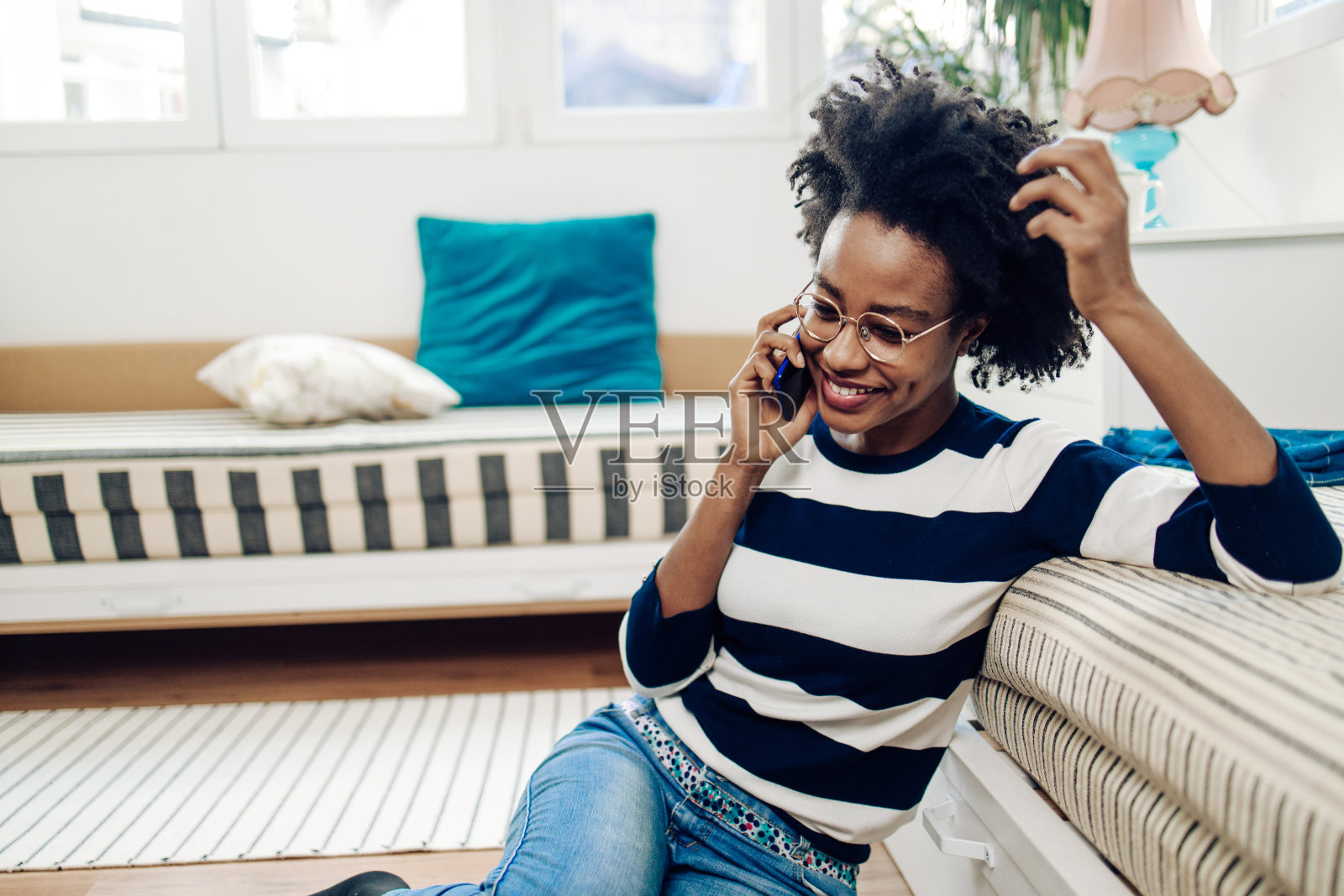快乐的非裔美国人在家里放松，打电话聊天照片摄影图片