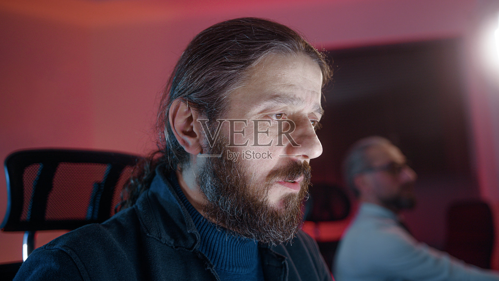 长发帅气的成年上班族在电脑上工作照片摄影图片