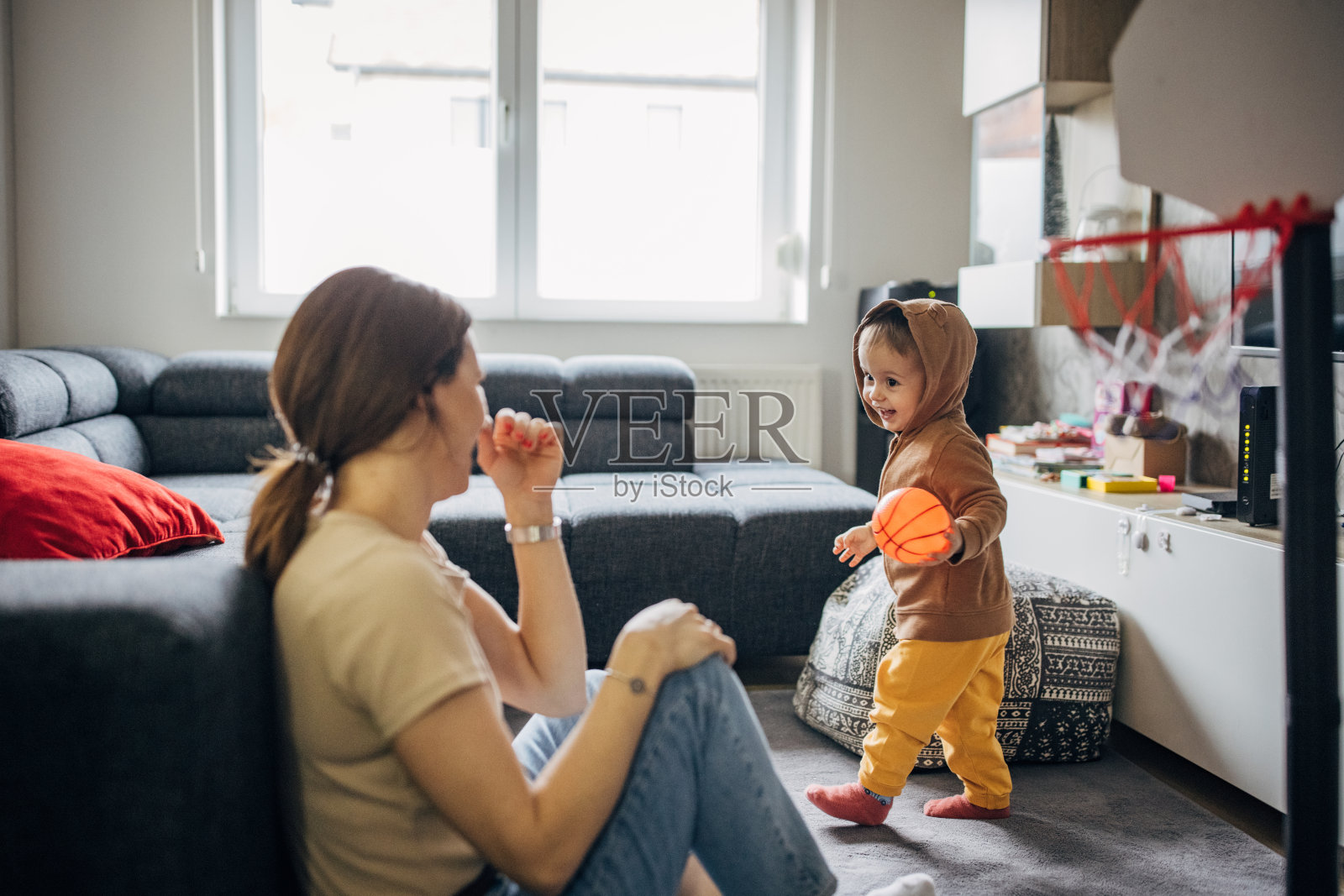 妈妈和儿子在家里的客厅里打篮球照片摄影图片