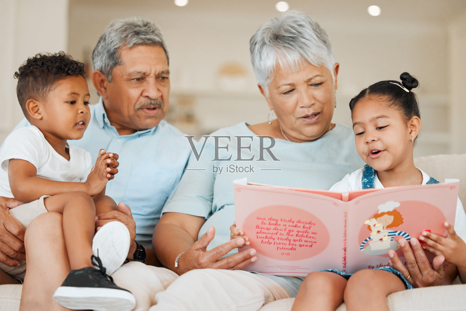 祖父母和他们的孙子在家里的沙发上照片摄影图片