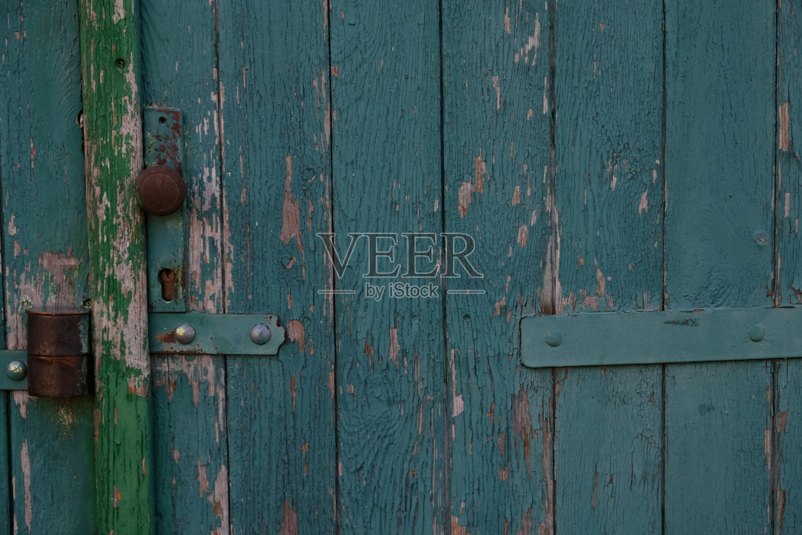 老式建筑的蓝色木漆门。破旧的木板门。旧的油漆门，剥落，破碎。老式金属门把手。破旧的木制乡村背景。照片摄影图片